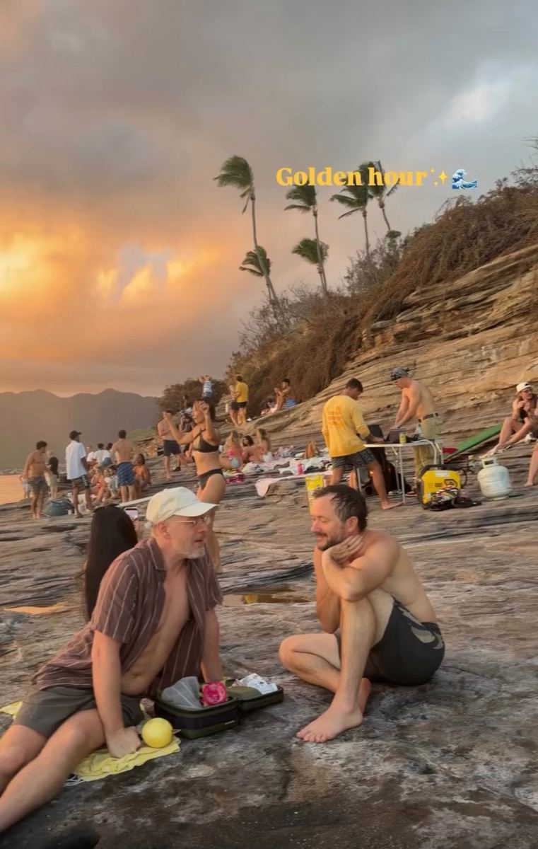 Friends gathered on the rocks at sunset