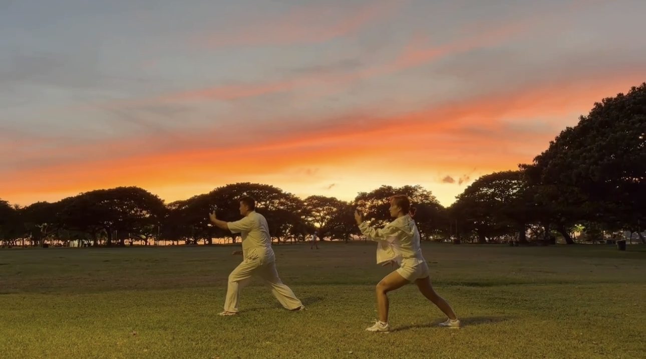 May and a student practicing Tai Chi together at sunrise, Magic Island